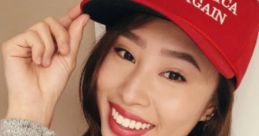 Kathy Zhu smiles and poses with a red "Make America Great Again" cap, showcasing her support for the campaign.