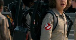 Dustin Henderson wears a Ghostbusters costume with a proton pack, showcasing adventure spirit in Stranger Things.