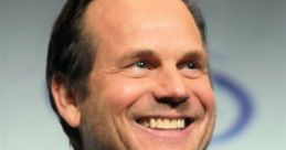 Bill Paxton smiling at an event, showcasing his charismatic personality and engaging presence. Iconic actor and director.