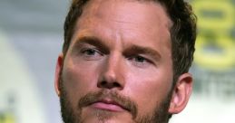 Chris Pratt at a panel, showcasing his thoughtful expression and casual style, representing his charismatic persona.