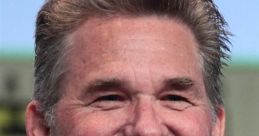 Kurt Russell smiling at a panel discussion, showcasing his iconic style and charm in a casual black shirt.