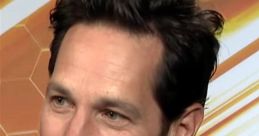 Paul Rudd smiling during an interview, dressed in a suit, showcasing his charismatic and charming personality.