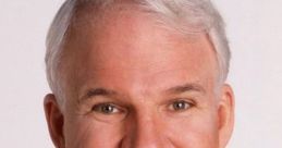 Steve Martin smiling in a dark suit with a blue shirt, showcasing his signature hairstyle and warm charisma.