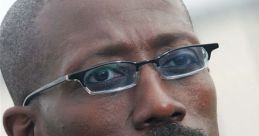 Wesley Snipes in a formal suit, showcasing a confident expression and stylish glasses, embodying charisma and professionalism.