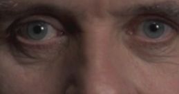 Close-up of Dr. Hannibal Lecter, showcasing his intense gaze and subtle smile, embodying his chilling yet captivating persona.