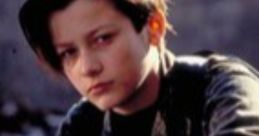 Young boy with short hair, gazing thoughtfully while sitting on a motorcycle, embodying the spirit of John Connor.