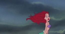 Ariel stands on a rock amidst crashing waves, looking towards the horizon in "The Little Mermaid" (1989) with longing.