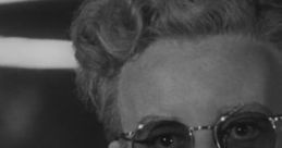 Dr. Strangelove character with glasses smiling, embodying dark comedy and satire of the nuclear age in classic film.