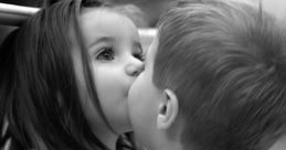 Two young children sharing a tender kiss, capturing the innocence and joy of love in a sweet moment of affection.