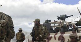 Soldiers in camouflage gear conduct a field operation near an armed vehicle in a rugged terrain setting.