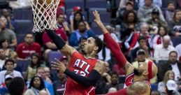 Player goes for a slam dunk in a high-energy basketball game, showcasing athleticism against a defender.