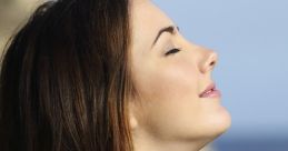 Woman practicing deep breathing outdoors, enjoying fresh air by the coast, promoting relaxation and mindfulness.