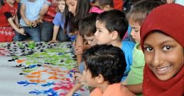 Children of diverse backgrounds create art together, showcasing inclusivity and creativity in a vibrant group setting.