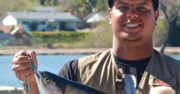 Fisherman proudly holds a large rainbow trout by a scenic lake, showcasing successful fishing trip.