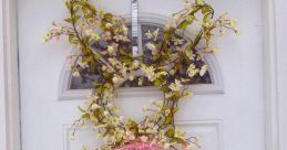 Spring-themed floral wreath on a white door, featuring delicate blossoms and a pink ribbon bow for decorative ideas.