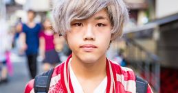 Stylish Japanese youth wearing a red embroidered bomber jacket with light gray hair, captured in a vibrant urban setting.