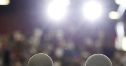 Microphones in focus with bright lights, capturing the anticipation in a crowded audience before an important speech.