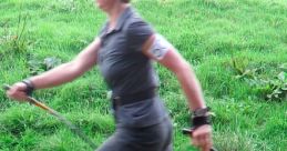 Woman walking energetically on grass with poles, showcasing fitness and agility in outdoor exercise.