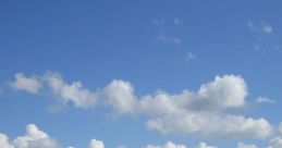 Vibrant green fields under a clear blue sky with fluffy clouds, showcasing a peaceful countryside scene and pleasant weather.