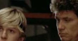 Johnny and his karate mentor look on during an intense moment in "The Karate Kid," showcasing their training journey.