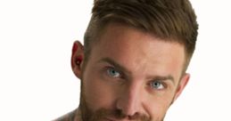 Aaron Chalmers, Geordie Shore star, showcasing his vibrant tattoo artwork and confident smile against a neutral background.