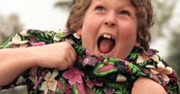 Chunk from The Goonies excitedly pulling at his colorful shirt, showcasing his playful spirit and iconic character.