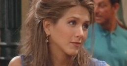 Rachel Green in a denim shirt with styled hair, giving a playful expression from the TV show Friends. Classic 90s fashion.