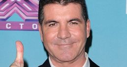 Simon Cowell giving a thumbs up at an X Factor event, showcasing his iconic style and confident demeanor.