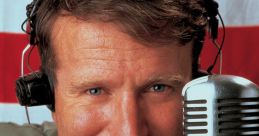 Adrian from "Good Morning Vietnam," playfully pointing while holding a microphone, capturing a moment of radio entertainment.