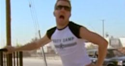 Terry Bernadino from Reno 911! striking a playful pose in colorful shorts and a tank top, showcasing a humorous moment.