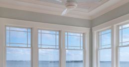 Bright sunroom with coastal decor, inviting seating, and views of calm waters, perfect for relaxation and inspiration.