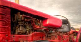 Close-up of a vintage red tractor showcasing its powerful tire and hydraulic machinery, highlighting agricultural efficiency.