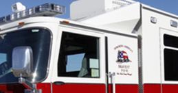 Red and white emergency vehicle with clear markings, designed for ambulance or fire rescue operations, parked outdoors.