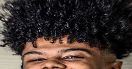 Smiling young man with curly hair, gold grill, and intricate neck tattoo, showcasing a bold and unique style.