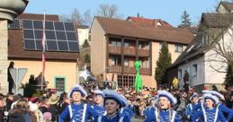 Women in blue costumes march cheerfully during a vibrant German Carnival parade, celebrating tradition and festivity.