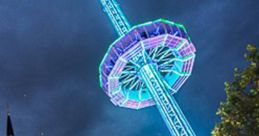 Thrilling ride at Tilburgse Kermis, illuminated by vibrant lights against a dramatic evening sky.