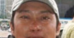 Smiling man in a casual blue shirt and cap, set against an urban background in Vietnam. Friendly local vibe.