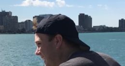 Young man enjoying a scenic view of the waterfront with city skyline, ideal for relaxation and inspiration.