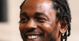 Kendrick Lamar smiles while wearing a stylish patterned shirt and chain necklace, exuding confidence and charm.