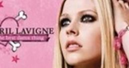 Avril Lavigne poses with a confident expression, showcasing her punk style against a vibrant pink background.