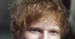 Ed Sheeran smiling, showcasing his signature tousled hair and casual style, exuding a relaxed, approachable vibe.