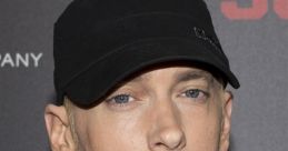 Eminem wearing a black cap and jacket, showcasing his signature style at a promotional event.