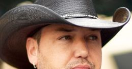 Jason Aldean in a stylish black suit with a cowboy hat, showcasing his signature country music star look at an event.