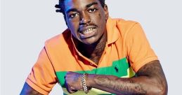 Kodak Black poses confidently in colorful attire, showcasing vibrant fashion and unique style with striking accessories.