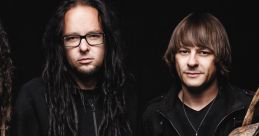 Korn band members pose together in black attire, showcasing their signature style and distinctive look in the music scene.