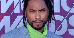 Miguel showcases bold fashion in a plaid suit and vibrant green turtleneck at the Radio Music Awards red carpet.