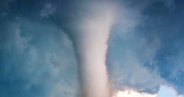 Massive tornado forming over a rural highway, showcasing dramatic clouds and a powerful vortex in the sky.