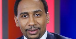 Stephen A. Smith in a blue suit with a vibrant pink tie and pocket square, known for his insightful sports commentary.