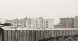 Subway train curves along elevated tracks with city buildings in the background, showcasing urban transit infrastructure.