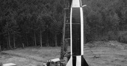 Launch site of a World War II German V2 Rocket, featuring support vehicles and technicians preparing for launch.